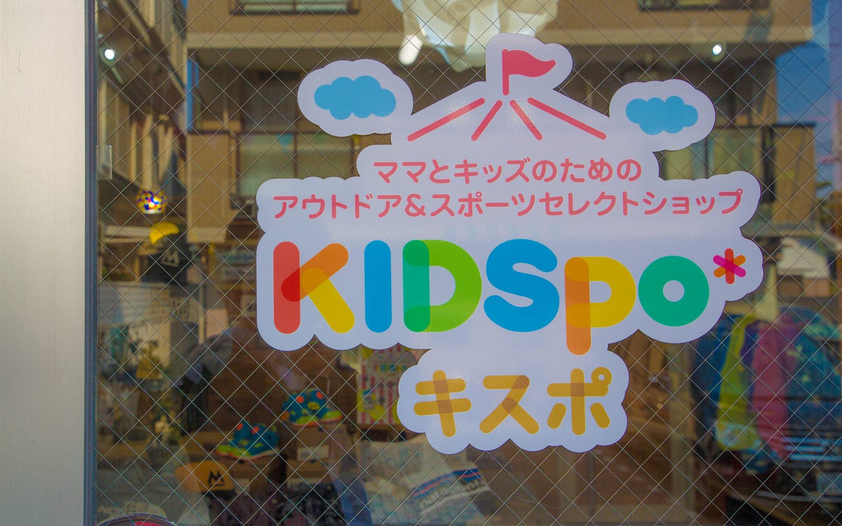 KIDSpo 豊中の店舗ファサード。ガラス面に「ママとキッズのためのアウトドア＆スポーツセレクトショップ KIDSpo」のサイン